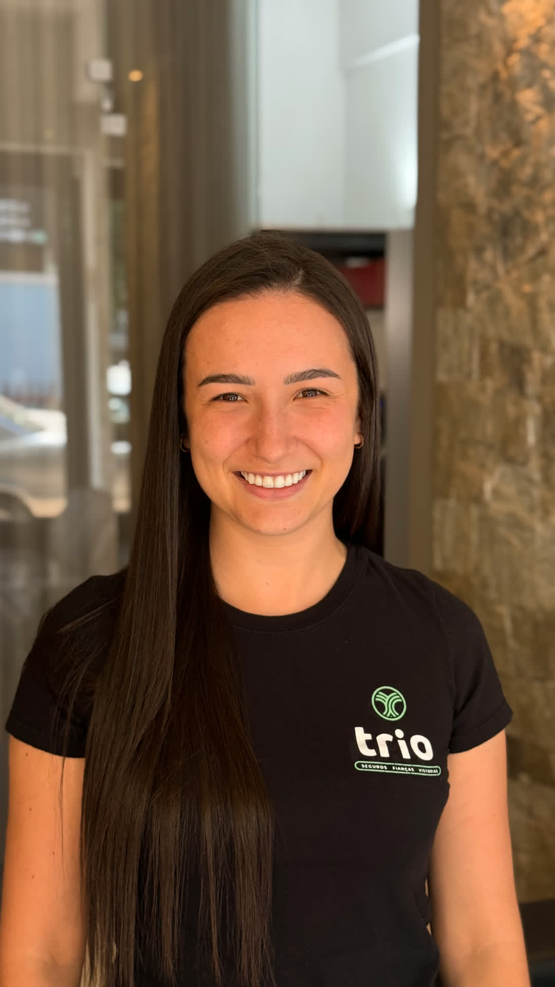 Fernanda, da equipe Trio, em retrato institucional sorrindo com camiseta Trio.