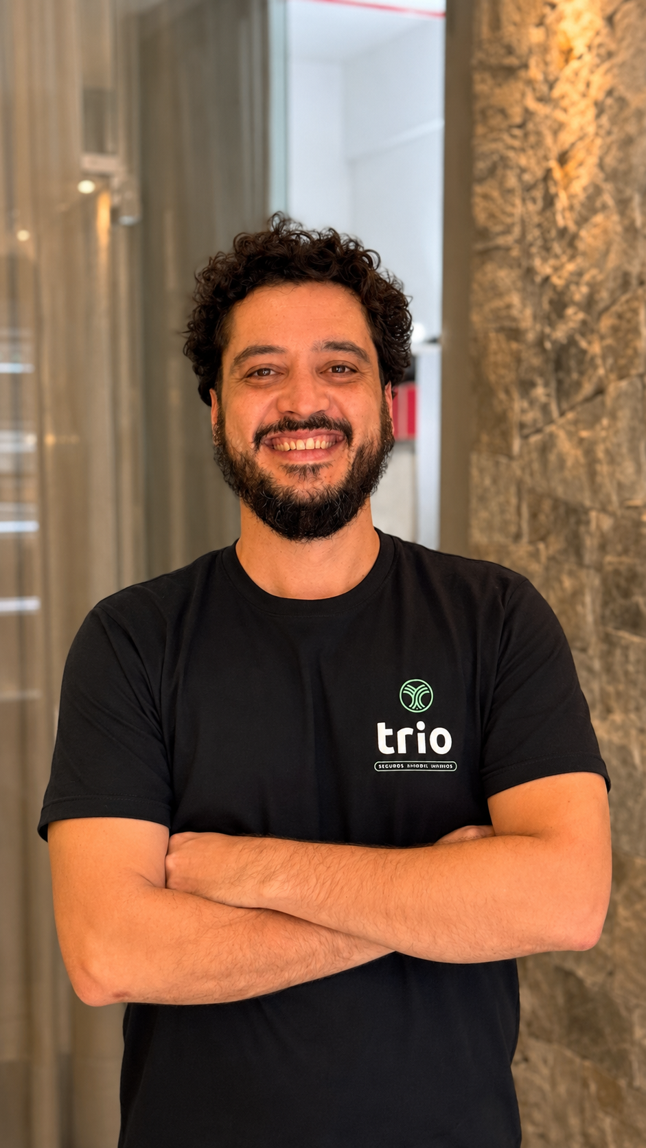 Thomas, da equipe Trio, em retrato institucional sorrindo com camiseta Trio.